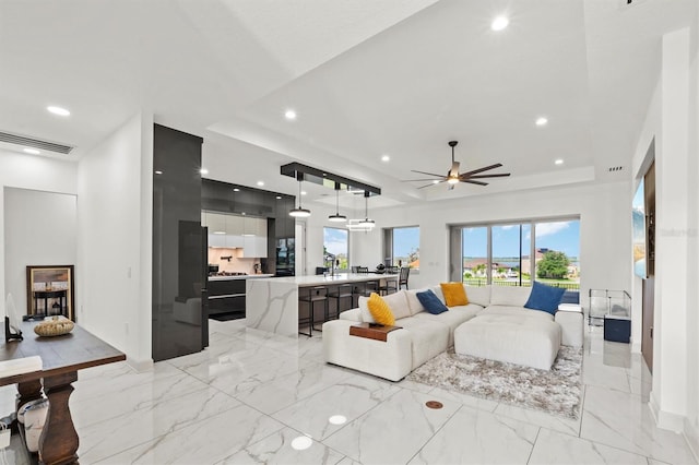 193 Stargrass Dr, Auburndale, FL 33823 - living room with a tray ceiling, ceiling fan, light marble finish flooring, recessed lighting, and baseboards