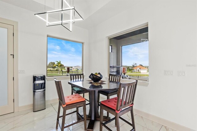 193 Stargrass Dr, Auburndale, FL 33823 - dining room with light marble finish floors, baseboards, and a chandelier