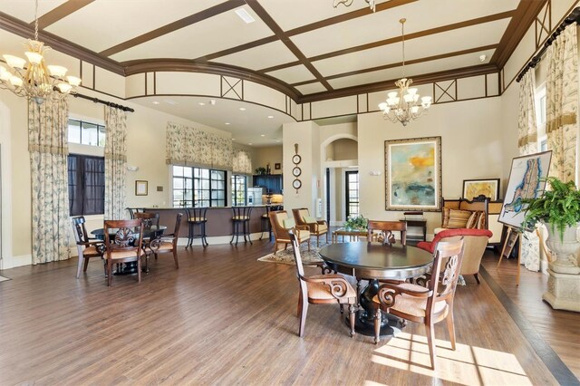 193 Stargrass Dr, Auburndale, FL 33823 - dining area featuring a chandelier, wood finished floors, arched walkways, baseboards, and a towering ceiling