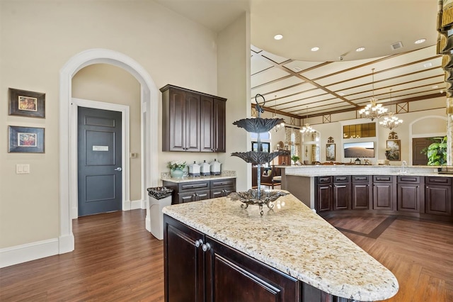 193 Stargrass Dr, Auburndale, FL 33823 - kitchen with a chandelier, dark brown cabinetry, a kitchen island, and baseboards