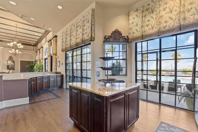 193 Stargrass Dr, Auburndale, FL 33823 - kitchen featuring healthy amount of natural light, a chandelier, wood finished floors, dark brown cabinets, and a high ceiling