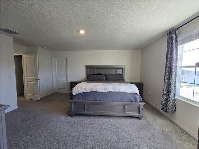 bedroom with carpet floors and a textured ceiling