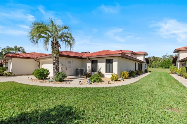 view of front of home with a front lawn, a garage, and cooling unit