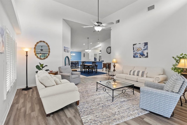 living room featuring ceiling fan, hardwood / wood-style floors, and vaulted ceiling