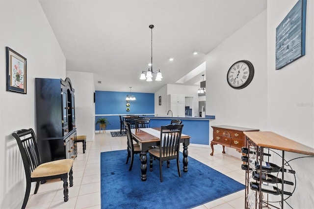 tiled dining room featuring a notable chandelier and sink