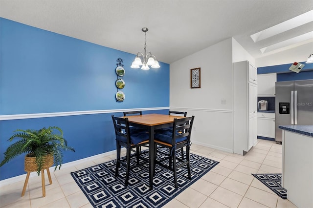 tiled dining room with vaulted ceiling with skylight, a textured ceiling, and a notable chandelier