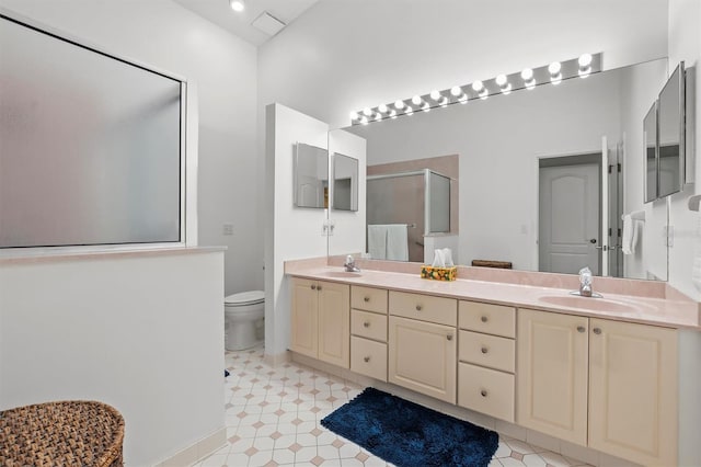 bathroom with vanity, toilet, and a shower with shower door