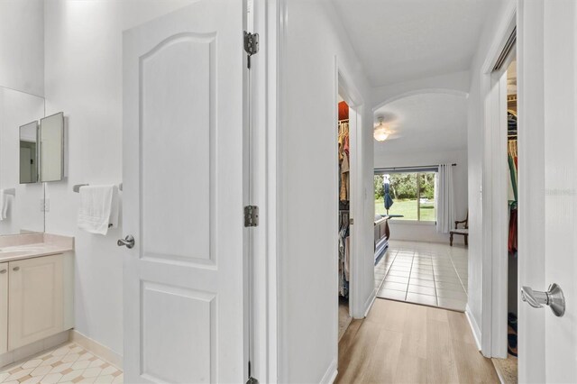 corridor with sink and light wood-type flooring