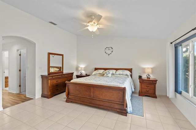 bedroom featuring ceiling fan, lofted ceiling, and light tile patterned flooring