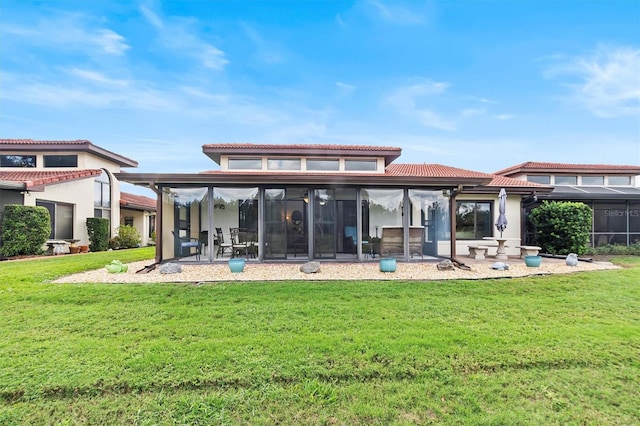 back of property with a patio area, a sunroom, and a yard