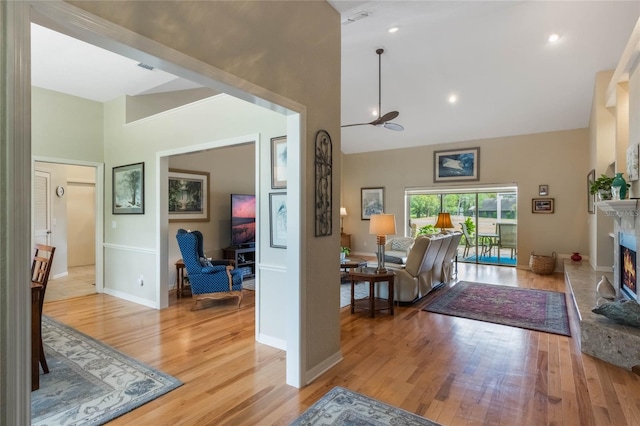 living room with light hardwood / wood-style floors and high vaulted ceiling