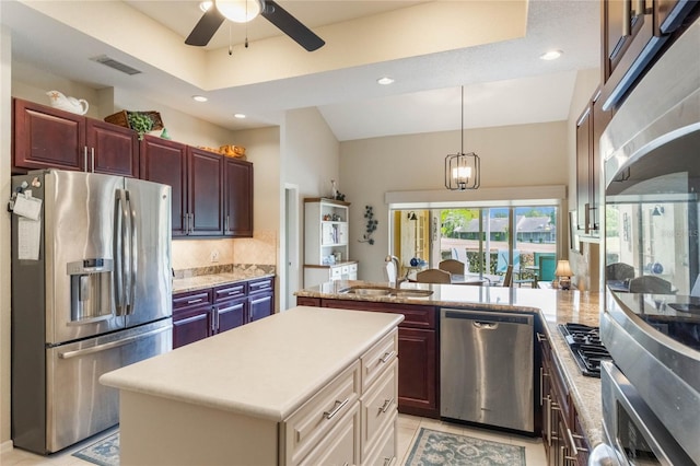 kitchen with ceiling fan with notable chandelier, a center island, sink, pendant lighting, and appliances with stainless steel finishes