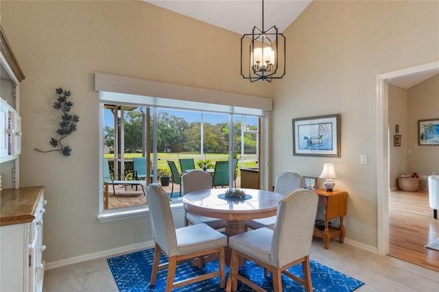 dining room featuring high vaulted ceiling, a notable chandelier, and light hardwood / wood-style floors