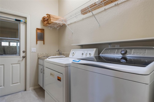 laundry area featuring cabinets, light tile patterned flooring, sink, and independent washer and dryer