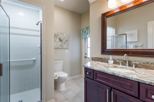 bathroom featuring toilet, vanity, tile patterned floors, and a shower with shower door