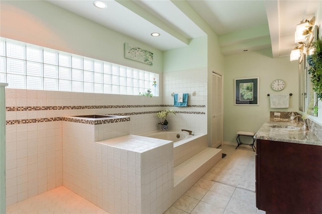 bathroom featuring tiled bath, vanity, and tile patterned floors