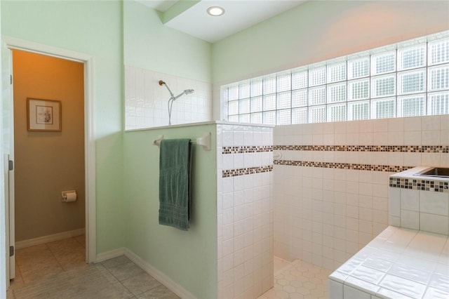 bathroom featuring tile patterned flooring and tiled shower