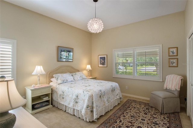 bedroom with light colored carpet and a chandelier