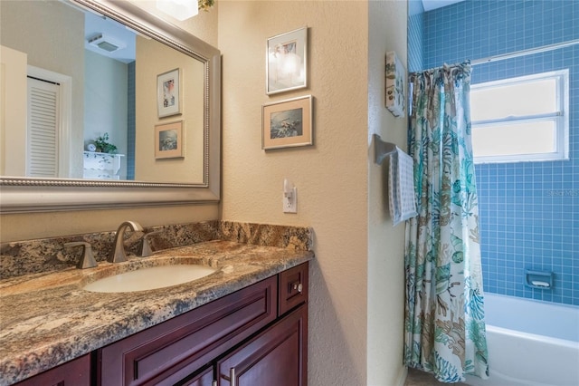 bathroom featuring vanity and shower / bathtub combination with curtain