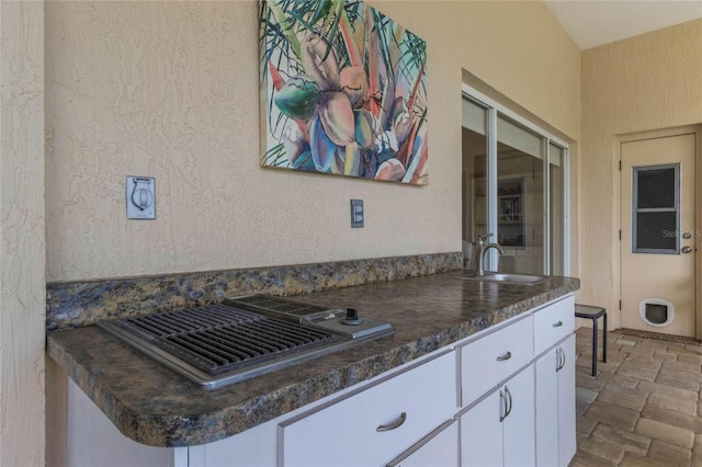 kitchen featuring white cabinets, sink, and kitchen peninsula