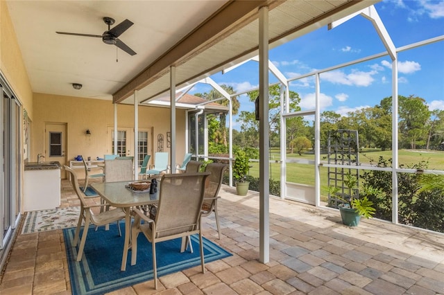 sunroom with ceiling fan and sink