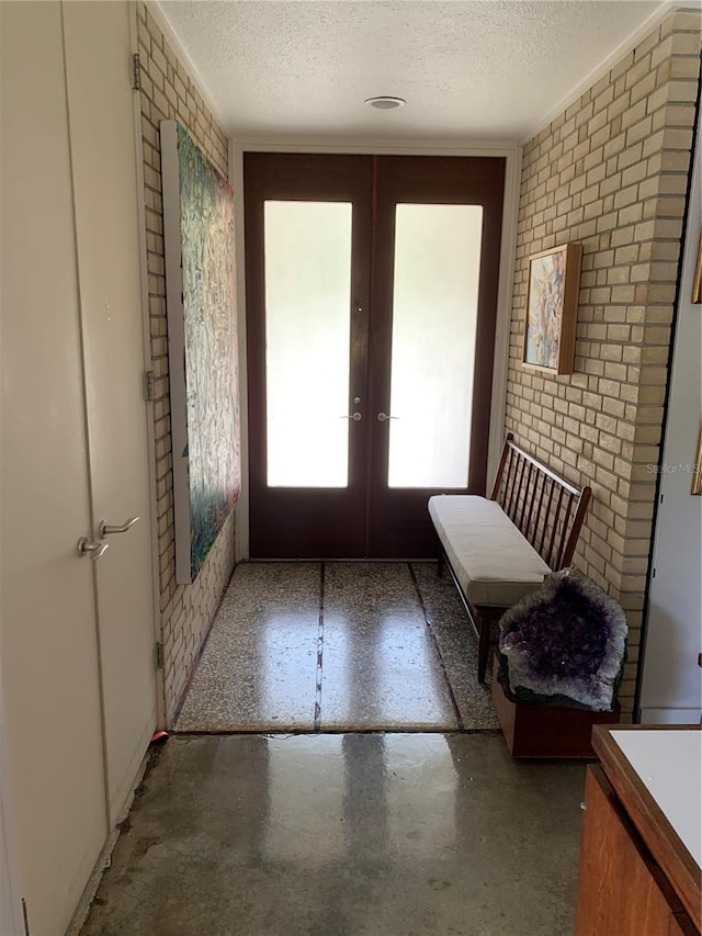 doorway featuring a textured ceiling, french doors, and concrete floors