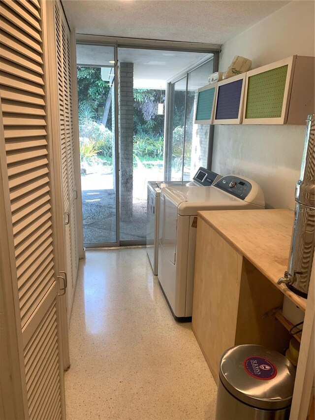 washroom featuring washing machine and dryer, a healthy amount of sunlight, and a textured ceiling