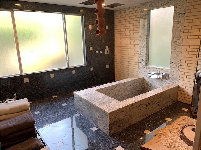 bathroom featuring ceiling fan and tile walls