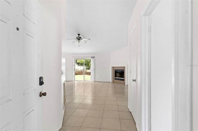 hallway with a textured ceiling and light tile patterned floors