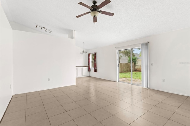 tiled spare room featuring rail lighting, ceiling fan with notable chandelier, a textured ceiling, and lofted ceiling