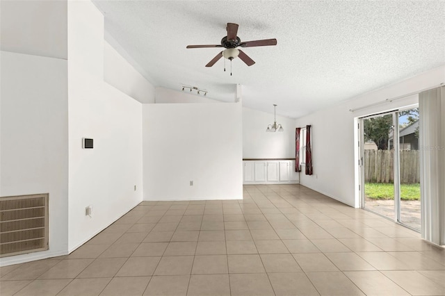 tiled empty room with ceiling fan with notable chandelier, a textured ceiling, and high vaulted ceiling