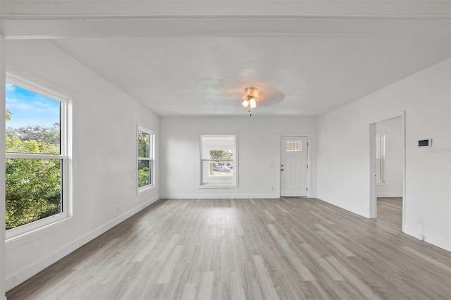 unfurnished living room featuring light hardwood / wood-style flooring, ceiling fan, and plenty of natural light