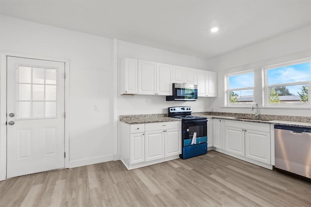 kitchen featuring white cabinets, light hardwood / wood-style floors, sink, and appliances with stainless steel finishes