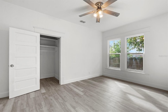 unfurnished bedroom with light wood-type flooring, ceiling fan, and a closet