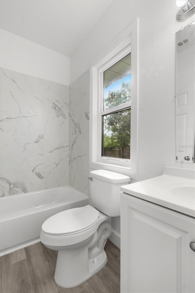 full bathroom with vanity, hardwood / wood-style flooring, toilet, and tiled shower / bath