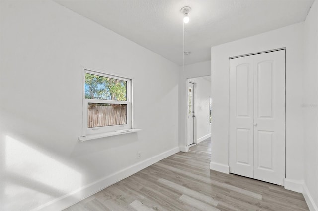 interior space with a textured ceiling and light wood-type flooring