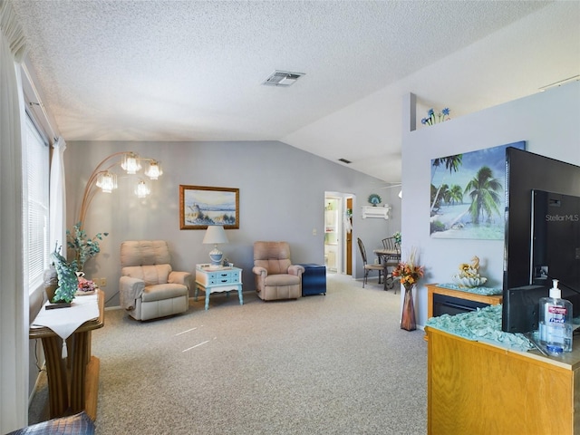 carpeted living room featuring lofted ceiling, a textured ceiling, and a notable chandelier