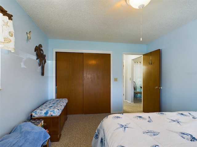 carpeted bedroom featuring a closet and a textured ceiling