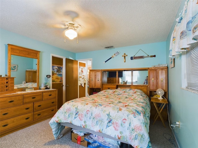 bedroom with carpet flooring, a textured ceiling, ceiling fan, and a closet