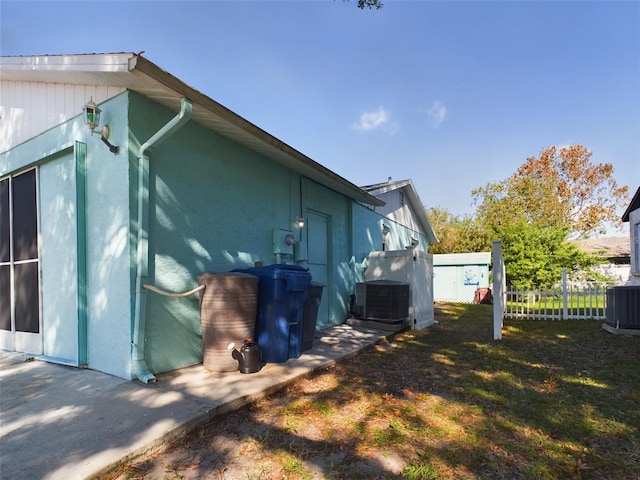 view of property exterior with a yard and cooling unit