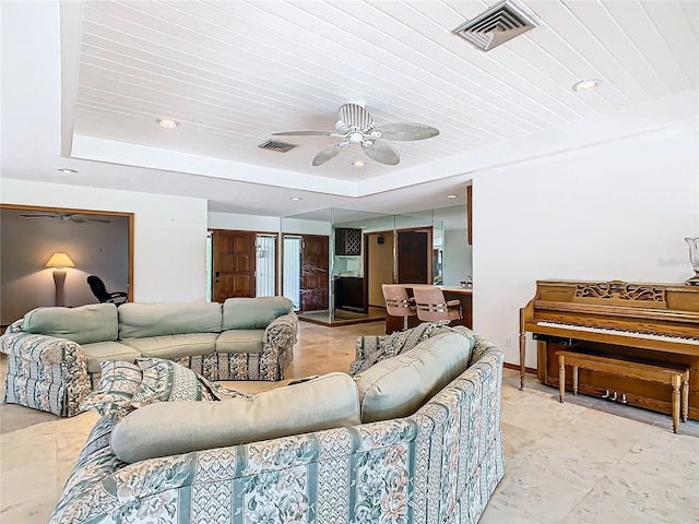 living room with a tray ceiling, ceiling fan, and wooden ceiling