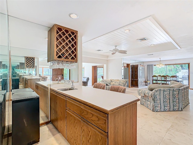 kitchen featuring kitchen peninsula, ceiling fan, and sink