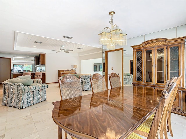 tiled dining room with ceiling fan with notable chandelier