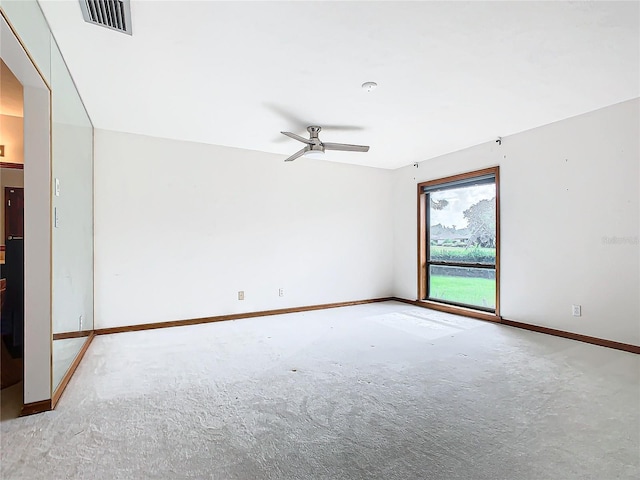 carpeted spare room featuring ceiling fan