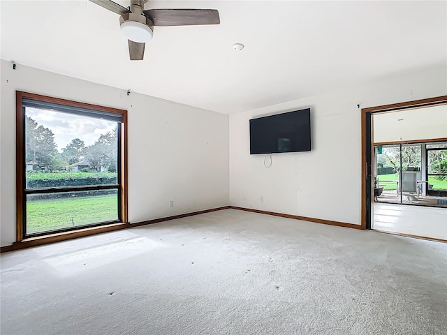 carpeted empty room featuring plenty of natural light and ceiling fan