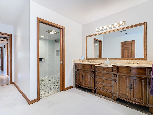 bathroom with tile patterned floors, vanity, and tiled shower