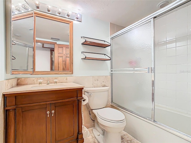 full bathroom with vanity, toilet, and bath / shower combo with glass door