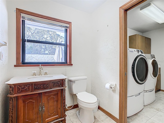 bathroom with tile patterned floors, vanity, toilet, and washing machine and clothes dryer