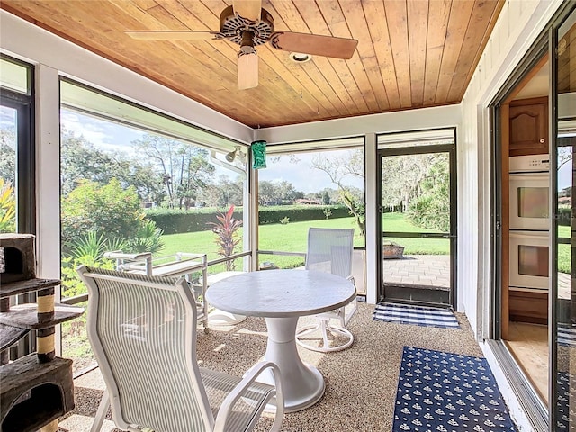 sunroom with ceiling fan, plenty of natural light, and wooden ceiling