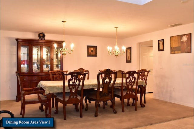 dining area with an inviting chandelier, light colored carpet, and visible vents